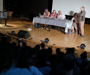 אולם תוכן מלא בקהל עם פאנל מרצים.